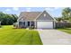 Charming home with blue shutters, a well-maintained lawn, and a two-car garage at 6401 Morehead Rd, Harrisburg, NC 28075