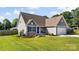 Charming home with blue shutters, a well-maintained lawn, and a two-car garage at 6401 Morehead Rd, Harrisburg, NC 28075