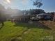 Waterfront property with a unique tiki bar structure and boat dock, surrounded by lush greenery and clear blue skies at 690 Lake Head Rd # 132, Norwood, NC 28128