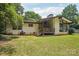 Backyard view of home featuring a brick exterior, deck, and mature trees at 7107 Cedarfield Rd, Charlotte, NC 28227