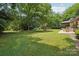 Beautiful grassy backyard with a fire pit and mature trees at 7107 Cedarfield Rd, Charlotte, NC 28227