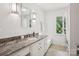 Bright bathroom featuring white cabinets, granite countertop, modern fixtures, and a window with a view at 7107 Cedarfield Rd, Charlotte, NC 28227