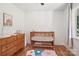 Sunlit bedroom features a wooden crib, dresser, hardwood floors and window with natural light at 7107 Cedarfield Rd, Charlotte, NC 28227