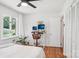 Bedroom featuring hardwood floors, ceiling fan, and a desk area with large windows overlooking the greenery at 7107 Cedarfield Rd, Charlotte, NC 28227