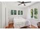 Bedroom featuring hardwood floors, ceiling fan, and a large window with curtains overlooking the greenery at 7107 Cedarfield Rd, Charlotte, NC 28227