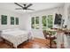Bedroom featuring hardwood floors, ceiling fan, and a desk area with a large window view at 7107 Cedarfield Rd, Charlotte, NC 28227