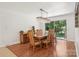Dining room with hardwood floors, large wooden table, and sliding glass door to the backyard at 7107 Cedarfield Rd, Charlotte, NC 28227