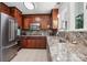 Well-lit kitchen with stainless steel appliances, custom cabinets, granite counters, and a stainless steel sink at 7107 Cedarfield Rd, Charlotte, NC 28227