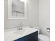 Bathroom featuring dark blue vanity with white countertop, toilet, large mirror, and shower with sliding glass doors at 7109 Forney Hill Rd, Denver, NC 28037