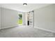 Bright bedroom featuring a sliding door, neutral carpet, and large window offering lots of natural light at 7109 Forney Hill Rd, Denver, NC 28037