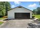 Detached garage with black garage door, white siding, and a paved driveway at 7109 Forney Hill Rd, Denver, NC 28037