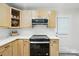 Modern kitchen with light wood cabinets, and sleek black appliances at 7109 Forney Hill Rd, Denver, NC 28037