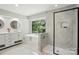 Bright bathroom featuring dual sinks, soaker tub, glass shower, and large picture window at 7109 Forney Hill Rd, Denver, NC 28037