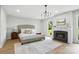 Bright main bedroom featuring a fireplace, recessed lighting, and large windows overlooking the backyard at 7109 Forney Hill Rd, Denver, NC 28037