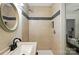 Shower with tile surround and built-in shelf, adjacent to modern vanity and toilet at 7109 Forney Hill Rd, Denver, NC 28037