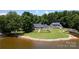 Waterfront property featuring well maintained lawns, two homes, and personal docks at 735 Pebble Pt, Salisbury, NC 28146