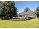 Beautiful backyard with black fence, lake views, mature tree coverage, and outdoor play set and dog house at 735 Pebble Pt, Salisbury, NC 28146