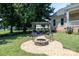 Beautiful backyard featuring a stone fire pit and covered outdoor seating area near the lake at 735 Pebble Pt, Salisbury, NC 28146
