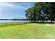 Spacious backyard with a black fence, grassy lawn, and fire pit at 735 Pebble Pt, Salisbury, NC 28146