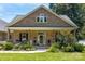 Charming stone and brick home featuring a welcoming front porch with decorative columns and mature landscaping at 735 Pebble Pt, Salisbury, NC 28146