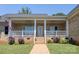 Charming brick home with a welcoming front porch, white railing, ceiling fans, and manicured landscaping at 735 Pebble Pt, Salisbury, NC 28146