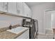 Functional laundry room showcasing ample cabinetry and modern black washer and dryer at 735 Pebble Pt, Salisbury, NC 28146