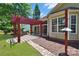 Spacious backyard featuring an outdoor kitchen with a red pergola, and a stone pathway at 8712 Soaring Eagle Ln, Waxhaw, NC 28173