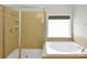 Relaxing bathroom featuring a separate shower and soaking tub with natural light at 8712 Soaring Eagle Ln, Waxhaw, NC 28173