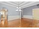 Open-concept dining area featuring hardwood floors, wainscoting, and a stylish chandelier at 8712 Soaring Eagle Ln, Waxhaw, NC 28173