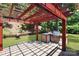 Inviting outdoor kitchen featuring a stone surround, grill, and red pergola at 8712 Soaring Eagle Ln, Waxhaw, NC 28173