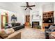 Spacious living room with a fireplace, built-in bookshelves, ceiling fan, and hardwood floors at 107 Creekwood Dr, Dallas, NC 28034