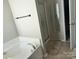 Bright bathroom featuring a tub, glass shower and neutral color palette at 10825 Traders Ct, Davidson, NC 28036