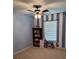 Neutral toned bedroom with blue and white striped accent wall and ceiling fan at 10825 Traders Ct, Davidson, NC 28036