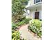 Inviting walkway leading to the front door, surrounded by lush landscaping and vibrant flowers at 10825 Traders Ct, Davidson, NC 28036