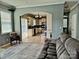 Living room with a gray sectional and view to the kitchen with white cabinetry at 10825 Traders Ct, Davidson, NC 28036