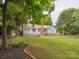 The backyard features lush greenery, a brick chimney, and a patio deck at 1109 Manchester Ln, Charlotte, NC 28227