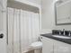Bathroom with granite countertop, vanity, commode, and shower/tub with white shower curtain at 1109 Manchester Ln, Charlotte, NC 28227