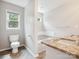 Bright bathroom with a granite countertop, soaking tub, and wood flooring at 1109 Manchester Ln, Charlotte, NC 28227