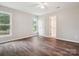 Bedroom with wood-look floors, neutral walls, two windows, and two white doors at 1109 Manchester Ln, Charlotte, NC 28227
