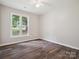 Bedroom featuring neutral walls, wood-look floors, a ceiling fan, and a window at 1109 Manchester Ln, Charlotte, NC 28227