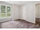 Bedroom with wood-look floors, neutral walls, a window, and a white closet door at 1109 Manchester Ln, Charlotte, NC 28227