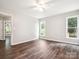 Bedroom with wood-look floors, neutral walls, two windows, and a doorway at 1109 Manchester Ln, Charlotte, NC 28227