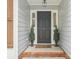 Charming front entrance with decorative plants, gray siding, and brick-lined porch at 1109 Manchester Ln, Charlotte, NC 28227
