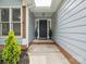 A welcoming front entrance features gray siding, decorative plants, and a brick-lined walkway at 1109 Manchester Ln, Charlotte, NC 28227