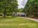 Landscaped single story home with mature trees, a two-car garage, and a well manicured lawn at 1109 Manchester Ln, Charlotte, NC 28227