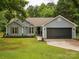 Charming single-story home featuring a well-manicured lawn, gray siding and a two-car garage at 1109 Manchester Ln, Charlotte, NC 28227
