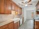 Kitchen featuring wood cabinets, tile backsplash, stainless steel appliances, and a ceiling fan at 1109 Manchester Ln, Charlotte, NC 28227