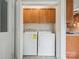 Conveniently located laundry closet features washer, dryer, and overhead cabinets at 1109 Manchester Ln, Charlotte, NC 28227