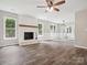 Living room boasts a brick fireplace, vinyl flooring, ceiling fan and lots of natural light at 1109 Manchester Ln, Charlotte, NC 28227