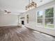 Large living room has a modern light fixture and a brick fireplace with mantel at 1109 Manchester Ln, Charlotte, NC 28227